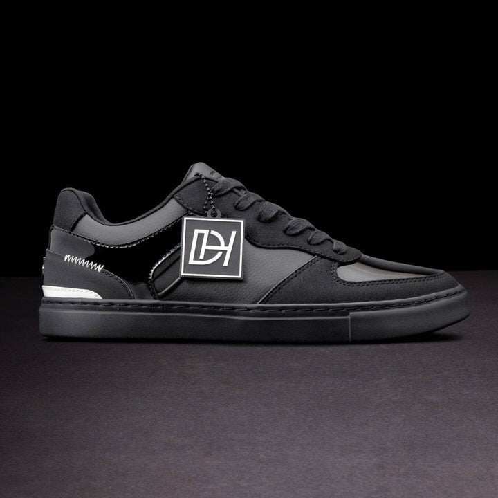 Black sneaker with a logo on a dark background
