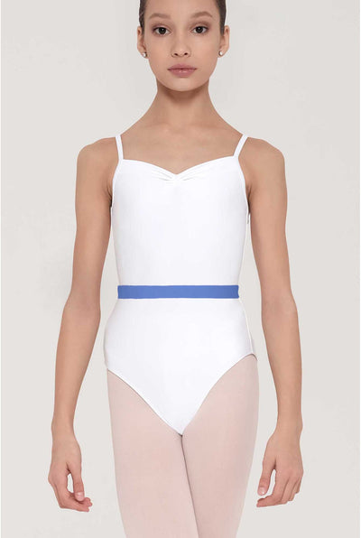 A young girl modeling a white ballet leotard with thin shoulder straps and a contrasting blue waistband, paired with light pink tights, against a solid light gray background.