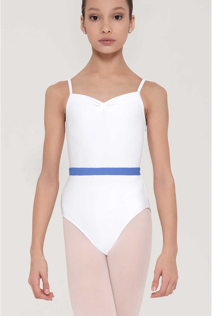 A young girl modeling a white ballet leotard with thin shoulder straps and a contrasting blue waistband, paired with light pink tights, against a solid light gray background.