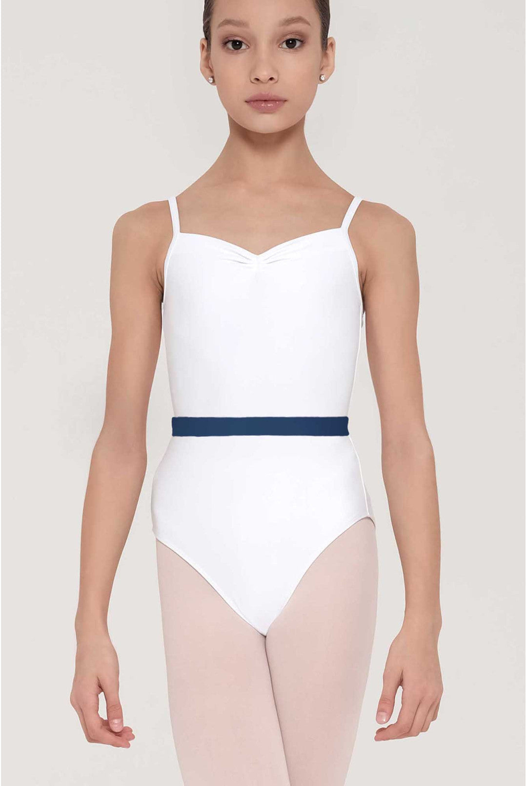 A young girl modeling a white ballet leotard with thin shoulder straps, a sweetheart neckline, and a contrasting navy blue waistband, paired with light pink tights against a light gray studio background.
