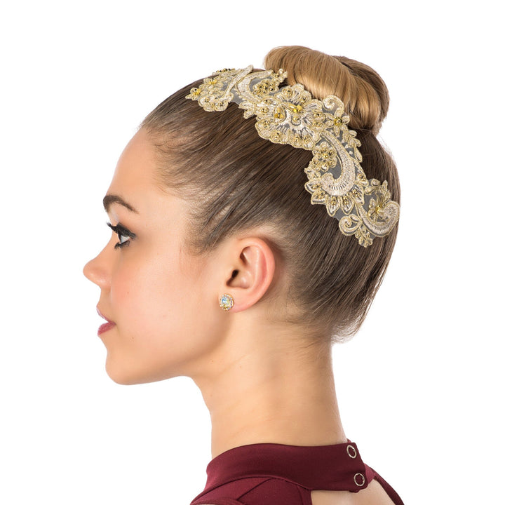 Woman wearing an ornate gold headband with a bun hairstyle on a white background