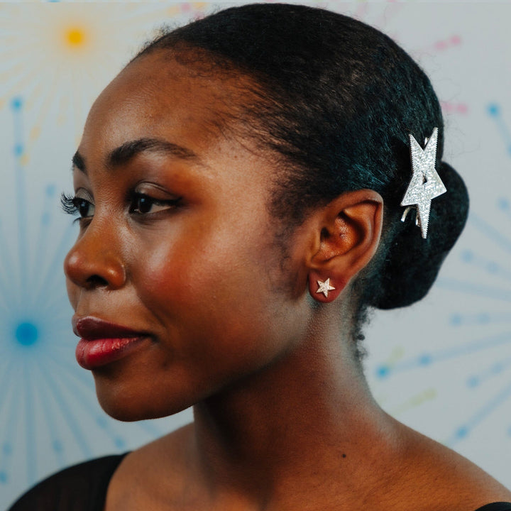 Woman with star-shaped earrings against a colorful abstract background