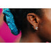 Close-up of an ear with a diamond earring and a blue scrunchie on a blurred background
