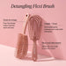 Detangling Flexi Brush with features highlighted on a pink background
