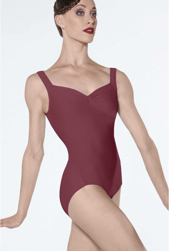Woman wearing a burgundy leotard on a white background