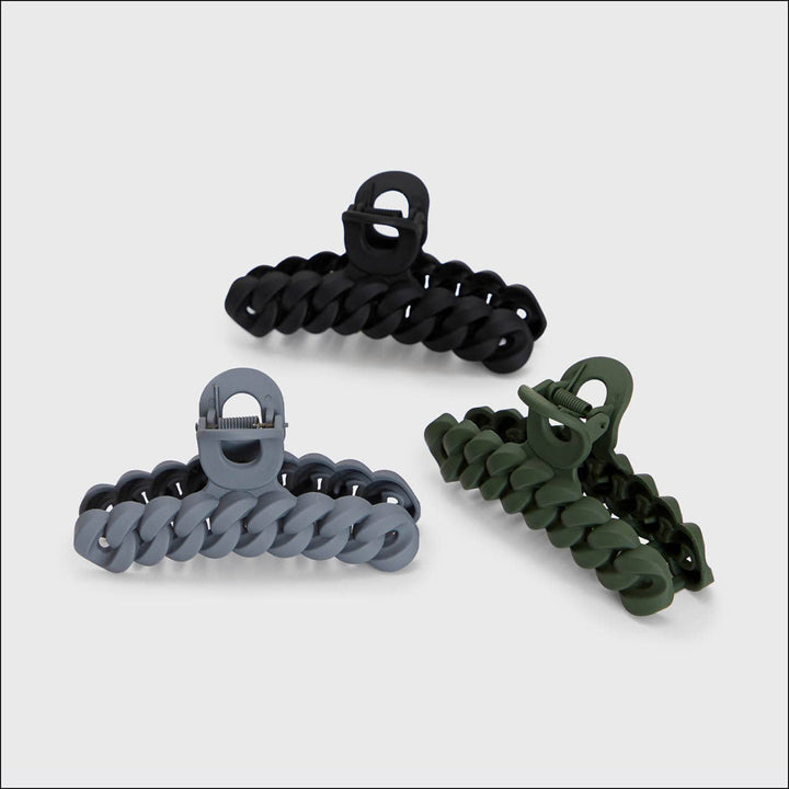 Three hair clips in black, gray, and green on a white background
