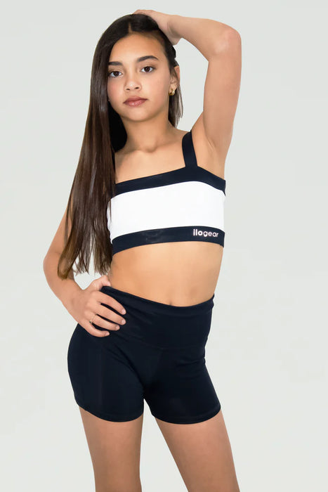 Person wearing a black and white sports bra and shorts set on a light gray background