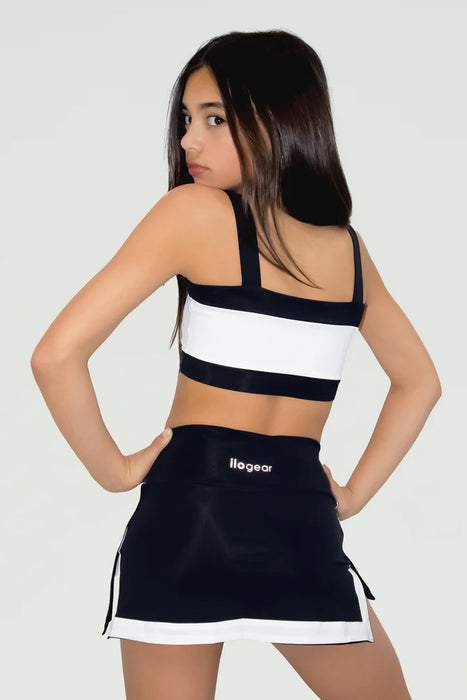 Woman wearing a black and white sports outfit with 'Leger' branding on a light gray background