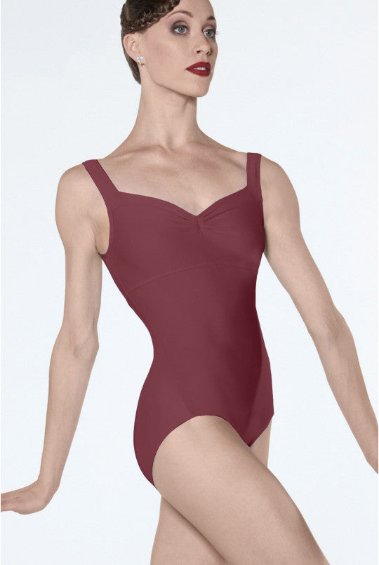Woman wearing a burgundy leotard on a white background