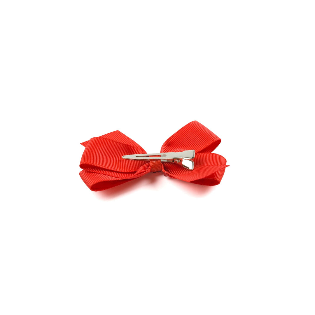 Red hair bow with a silver clip on a white background
