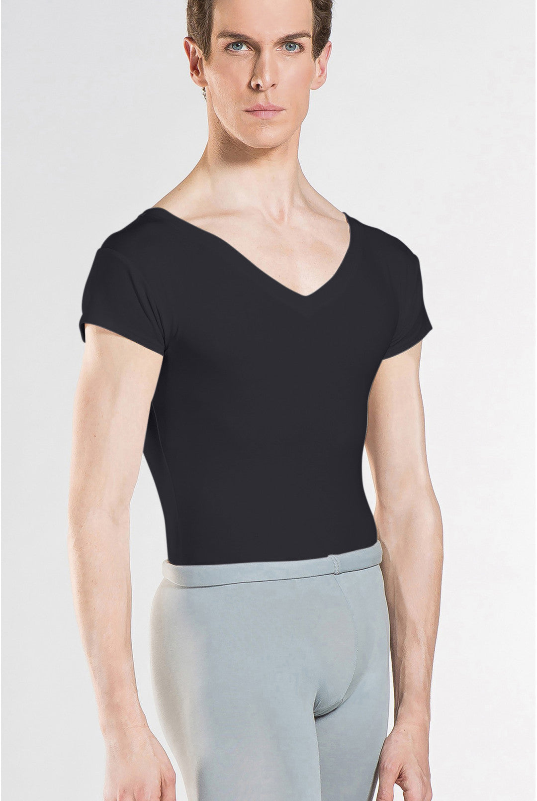 Person wearing a black cap sleeve leotard and light gray pants on a white background