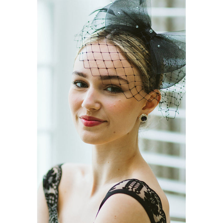 Woman wearing a black lace dress and headpiece with a veil.