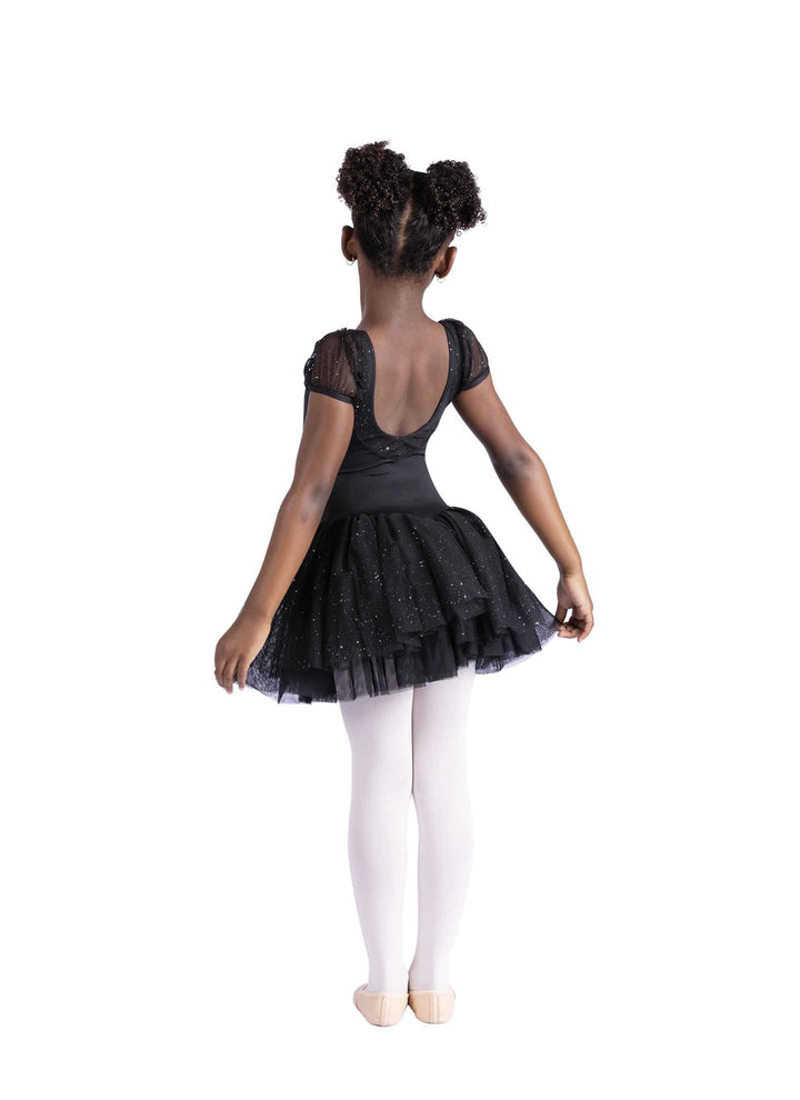 Little dancer in black dress facing away on a white background