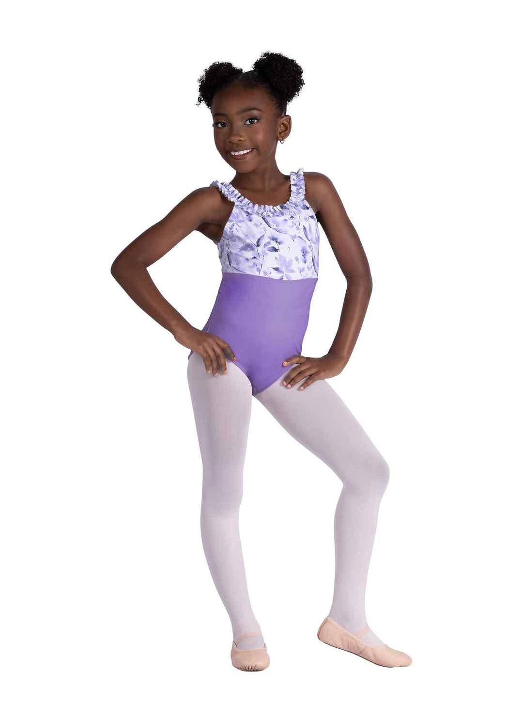Young girl in a ballet outfit with a floral top and purple leotard on a white background