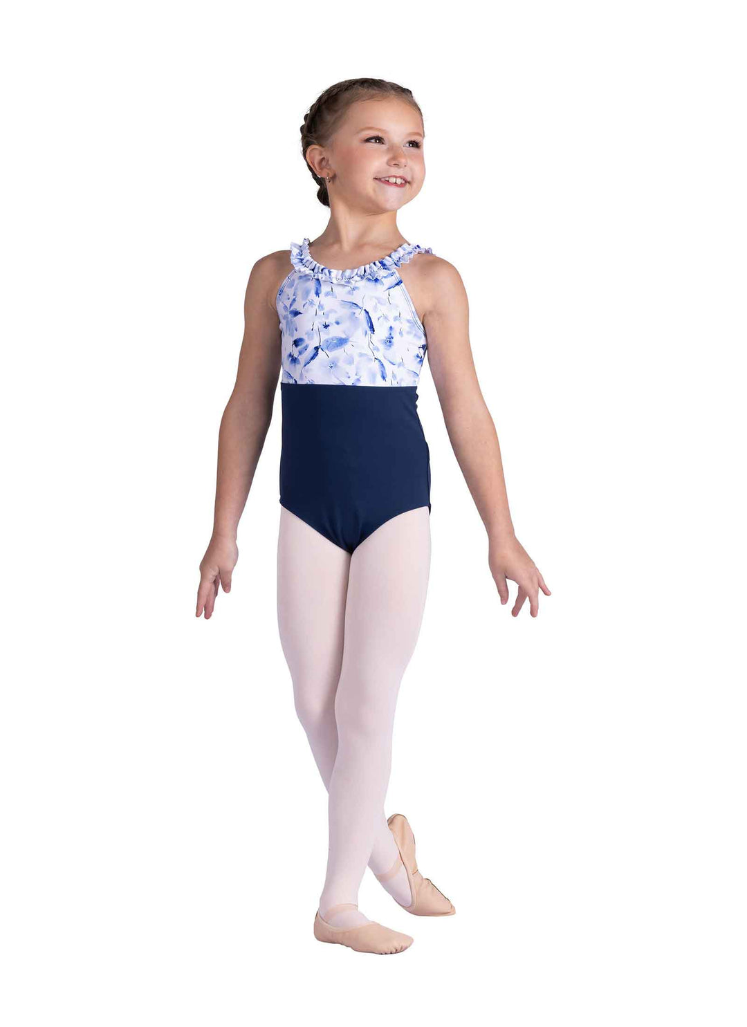 Young girl in a floral tank top and navy leotard on a white background