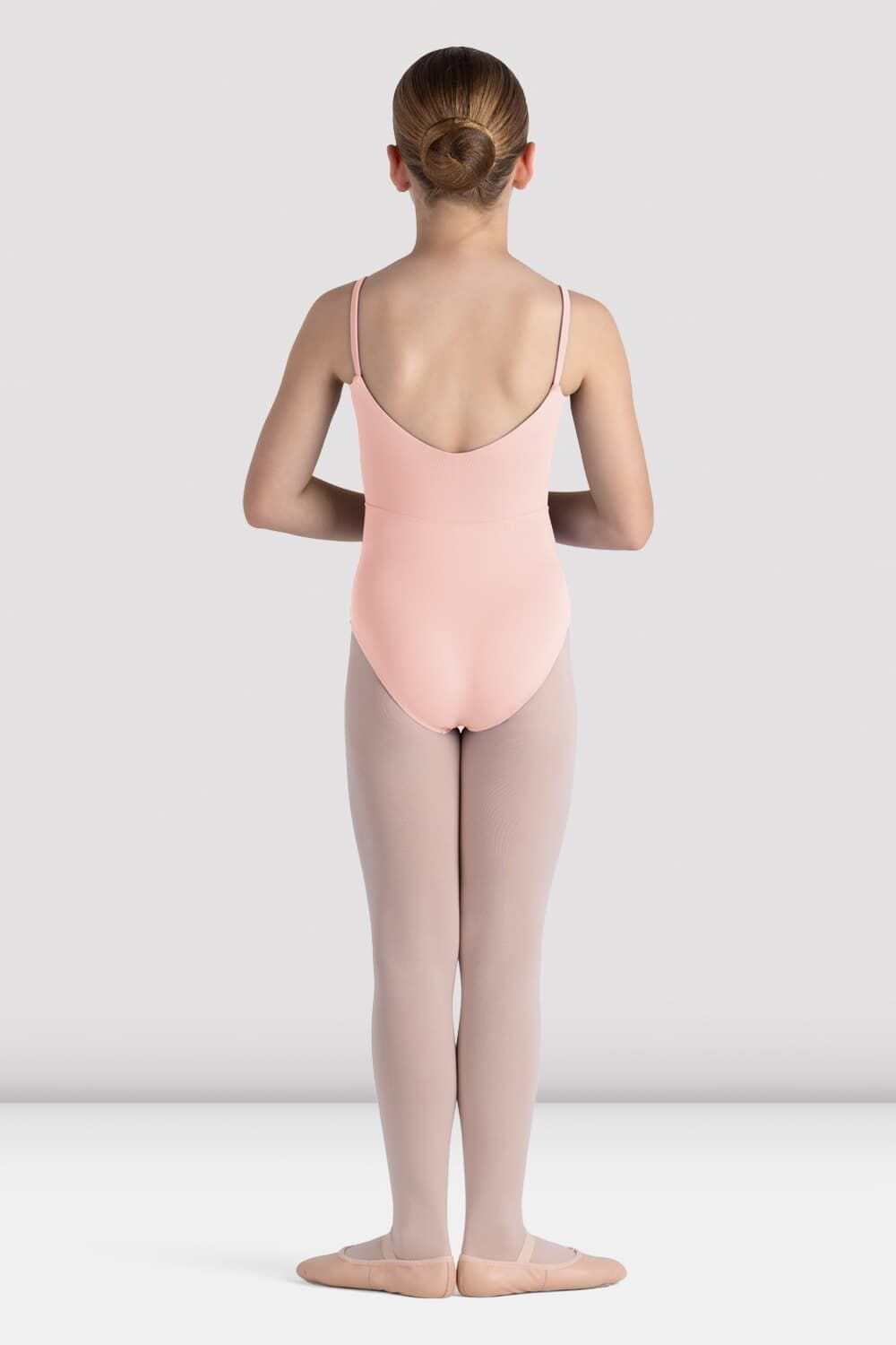 Ballerina in a pink leotard and gray tights standing against a white background