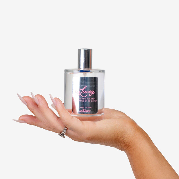 Hand holding a perfume bottle labeled 'Lacey' against a white background