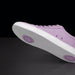 Purple sneaker with white sole on a black background