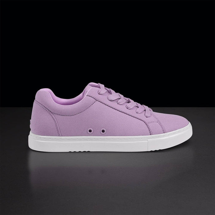 Purple sneaker with white sole on a black background