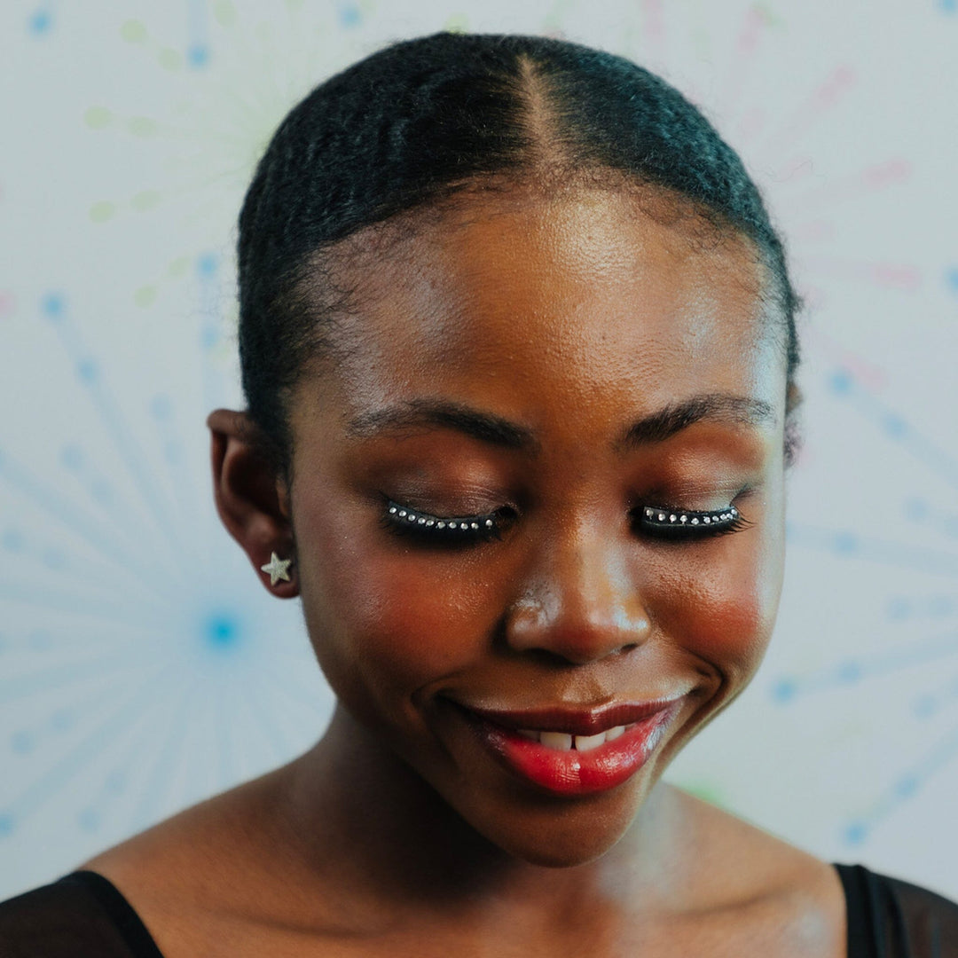 Woman with a star earring against a colorful abstract background