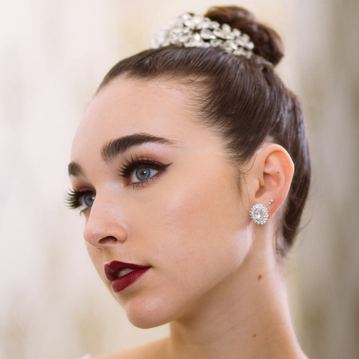 Close-up of a woman wearing diamond earrings with a blurred background
