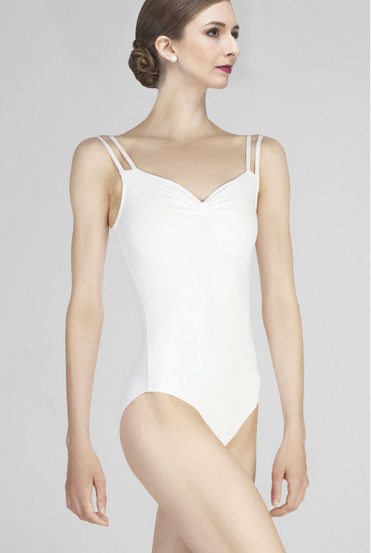 Woman wearing a white leotard against a plain background