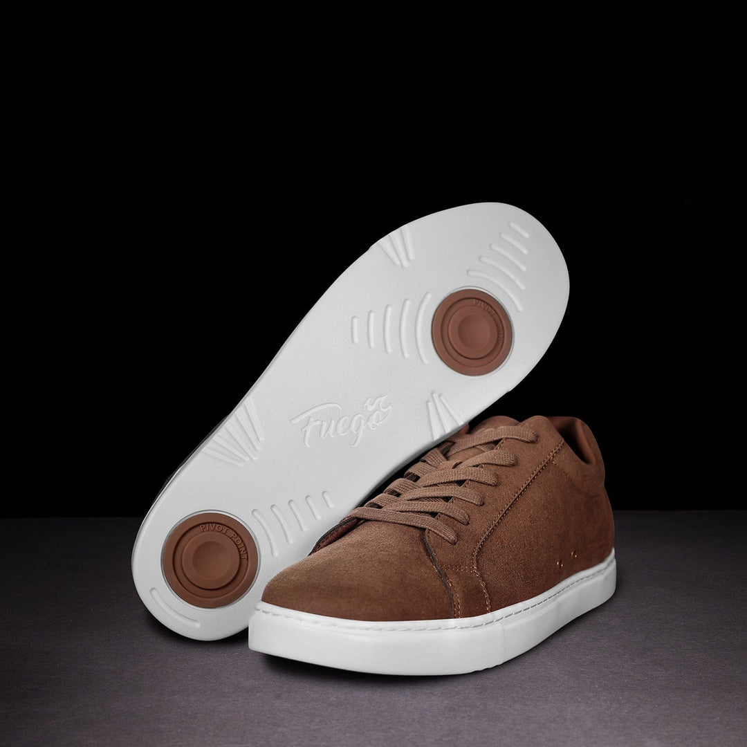 Brown suede sneaker with white sole on a dark background