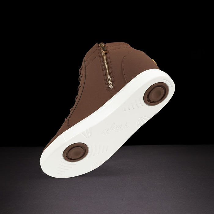 Brown sneaker with white sole on a black background