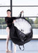 Dancer holding a large black bag with a white fan-like object inside, in a studio setting.