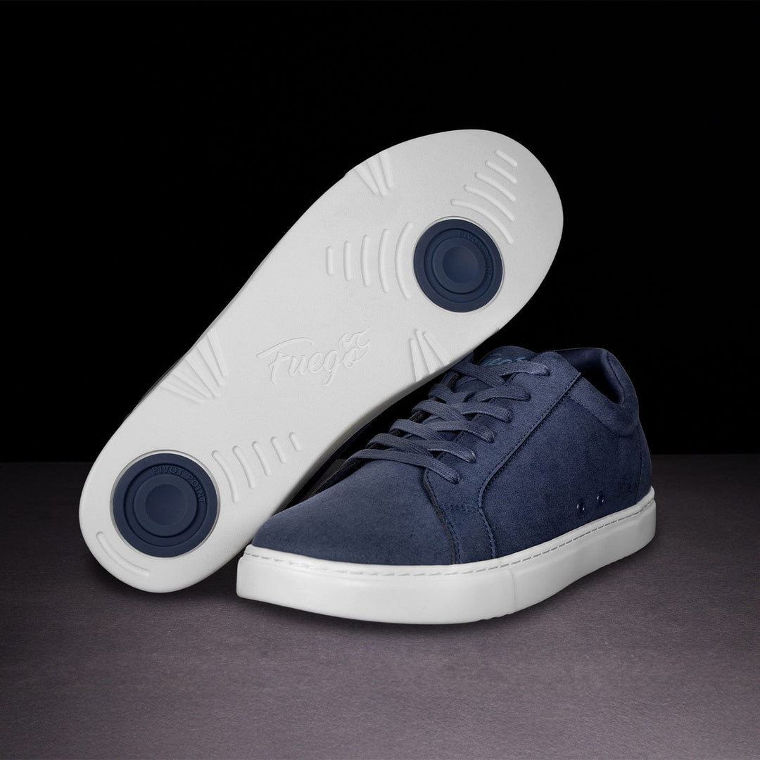 Navy blue sneakers with white soles on a dark background