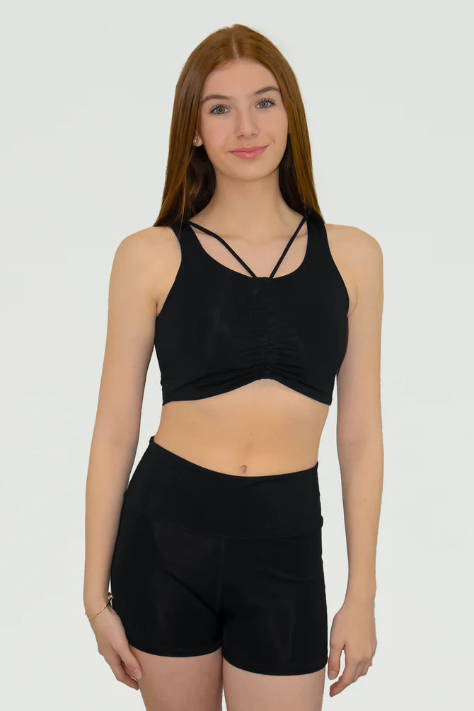 Woman wearing a black sports bra and shorts on a white background