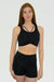 Woman wearing a black sports bra and shorts on a white background