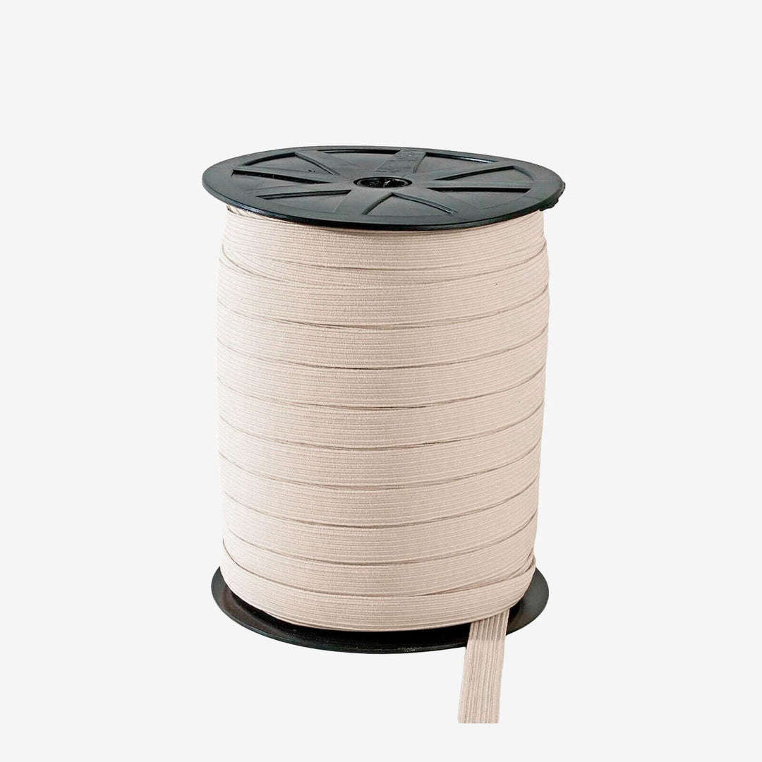 Spool of beige ribbon on a white background