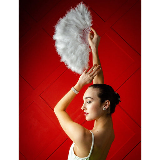 Woman holding a white feathered fan against a red background