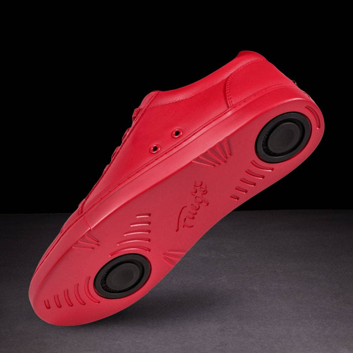 Red shoe with black sole on a dark background