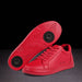 Red sneakers with a black sole on a dark background
