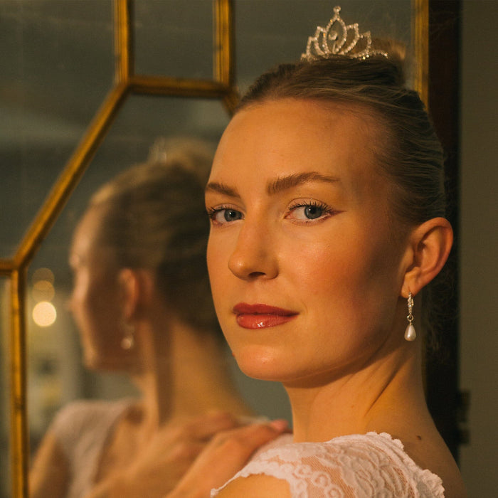 Woman wearing a tiara in front of a mirror
