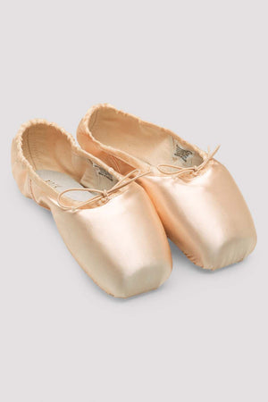 Pair of beige ballet shoes on a light gray background